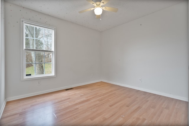 unfurnished room featuring ceiling fan, a textured ceiling, and light wood-type flooring