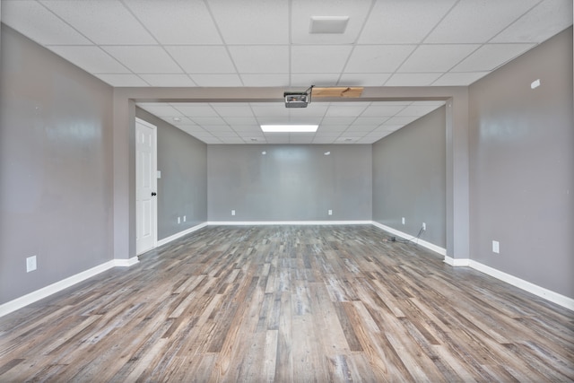 unfurnished room with a paneled ceiling and wood-type flooring