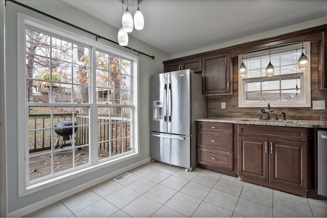 kitchen featuring dark brown cabinets, light tile patterned flooring, backsplash, and appliances with stainless steel finishes