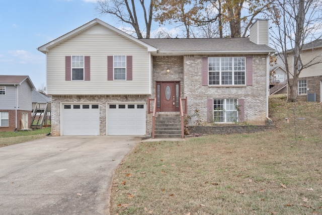 raised ranch with a front yard and a garage