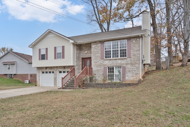 split foyer home featuring a garage and a front lawn