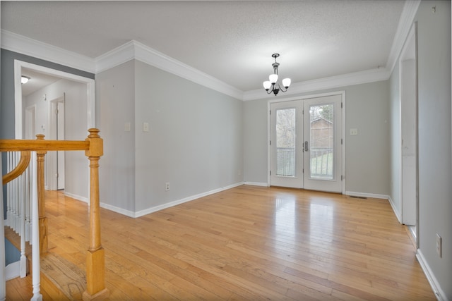 unfurnished room with crown molding, a chandelier, and light wood-type flooring