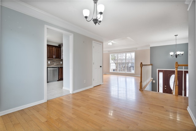 empty room with crown molding, light wood-type flooring, and a notable chandelier