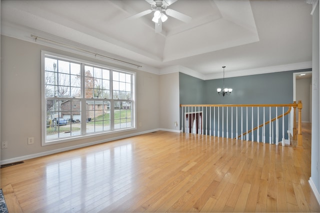 unfurnished room featuring ceiling fan with notable chandelier, light hardwood / wood-style flooring, a healthy amount of sunlight, and crown molding