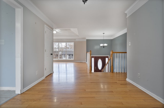 hallway featuring crown molding, light hardwood / wood-style flooring, and an inviting chandelier