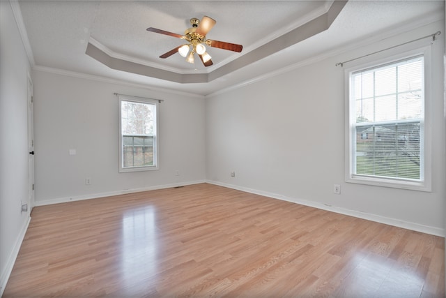 spare room featuring ornamental molding, light hardwood / wood-style flooring, ceiling fan, and a healthy amount of sunlight