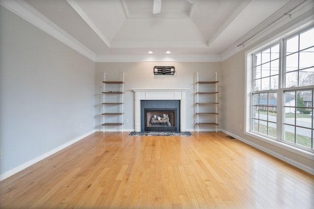 unfurnished living room with a tile fireplace, wood-type flooring, crown molding, and a healthy amount of sunlight