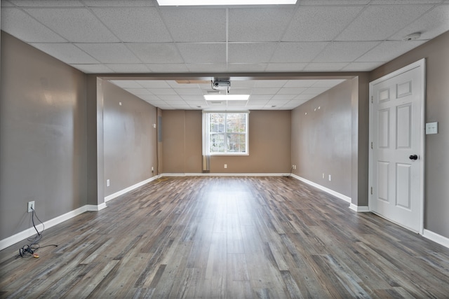 empty room with wood-type flooring and a paneled ceiling