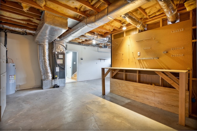 basement with a workshop area, electric water heater, and heating unit