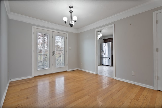 empty room with light hardwood / wood-style flooring, ornamental molding, french doors, and a notable chandelier