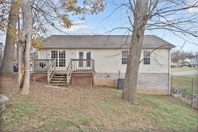 back of house featuring a lawn, cooling unit, a wooden deck, and french doors