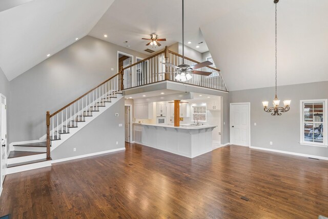 1055 Wades Branch Rd, Centerville, TN 37033 - unfurnished living room featuring high vaulted ceiling, ceiling fan, stairway, wood finished floors, and a chandelier