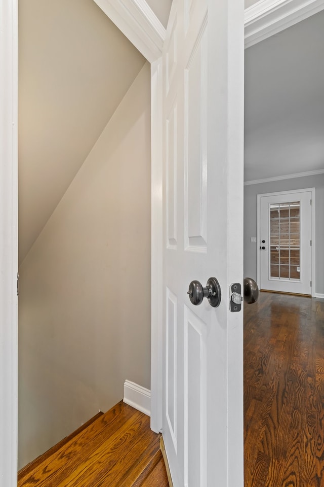 stairs with wood-type flooring and crown molding