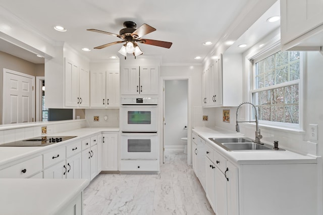 kitchen featuring black electric stovetop, ornamental molding, double oven, sink, and white cabinets