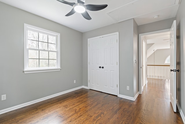 unfurnished bedroom featuring ceiling fan, a closet, and dark wood-type flooring