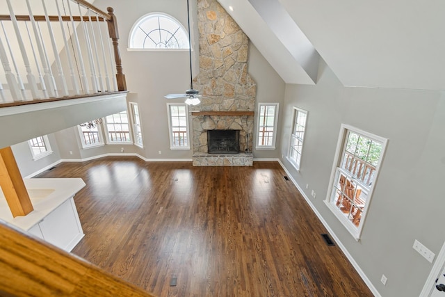 1055 Wades Branch Rd, Centerville, TN 37033 - unfurnished living room with a high ceiling, plenty of natural light, a fireplace, wood finished floors, and a ceiling fan