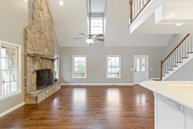 unfurnished living room with plenty of natural light, dark hardwood / wood-style floors, and high vaulted ceiling