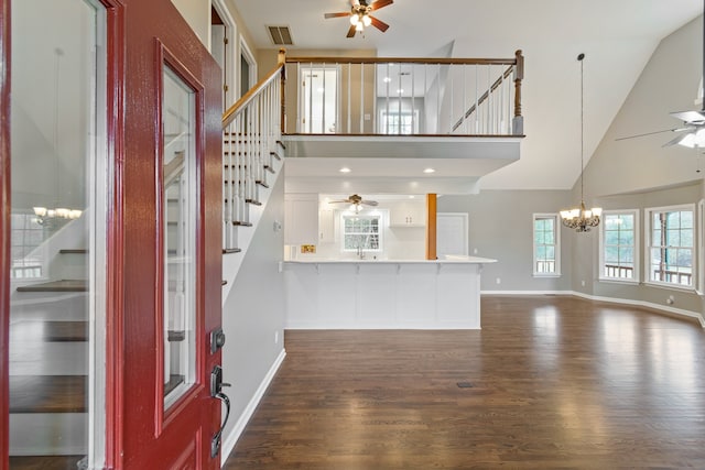 foyer entrance featuring ceiling fan with notable chandelier, dark hardwood / wood-style floors, high vaulted ceiling, and sink