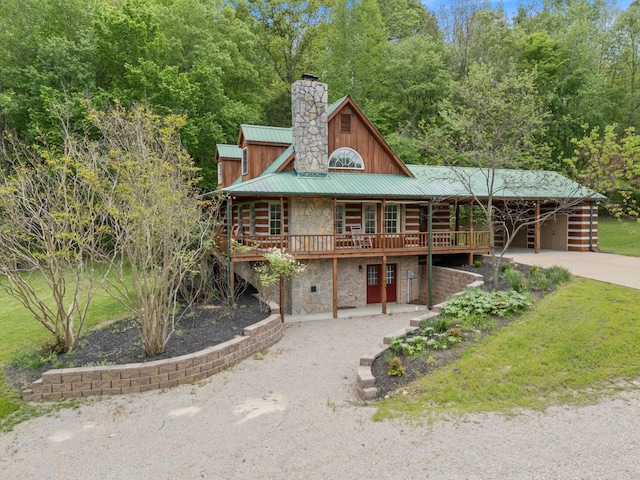 1055 Wades Branch Rd, Centerville, TN 37033 - cabin with stone siding, concrete driveway, metal roof, a chimney, and a deck