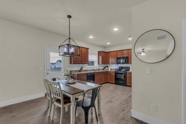 dining room featuring sink, light hardwood / wood-style floors, and ceiling fan with notable chandelier