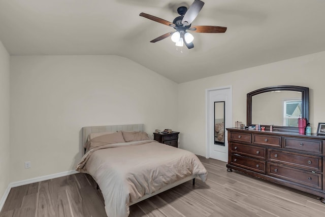 bedroom with ceiling fan, light hardwood / wood-style floors, and lofted ceiling