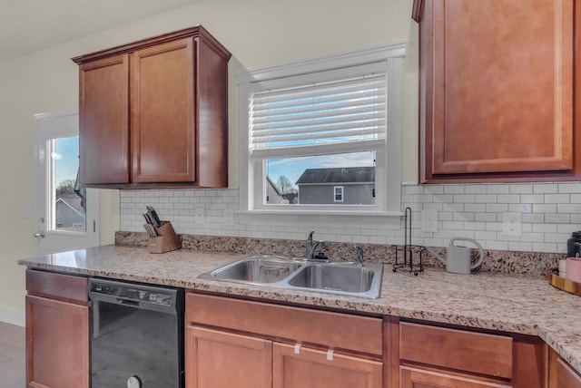 kitchen featuring decorative backsplash, sink, and black dishwasher