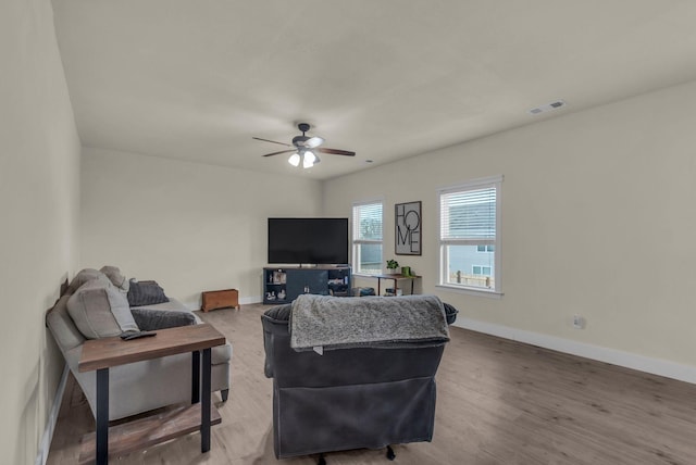 living room with wood-type flooring and ceiling fan