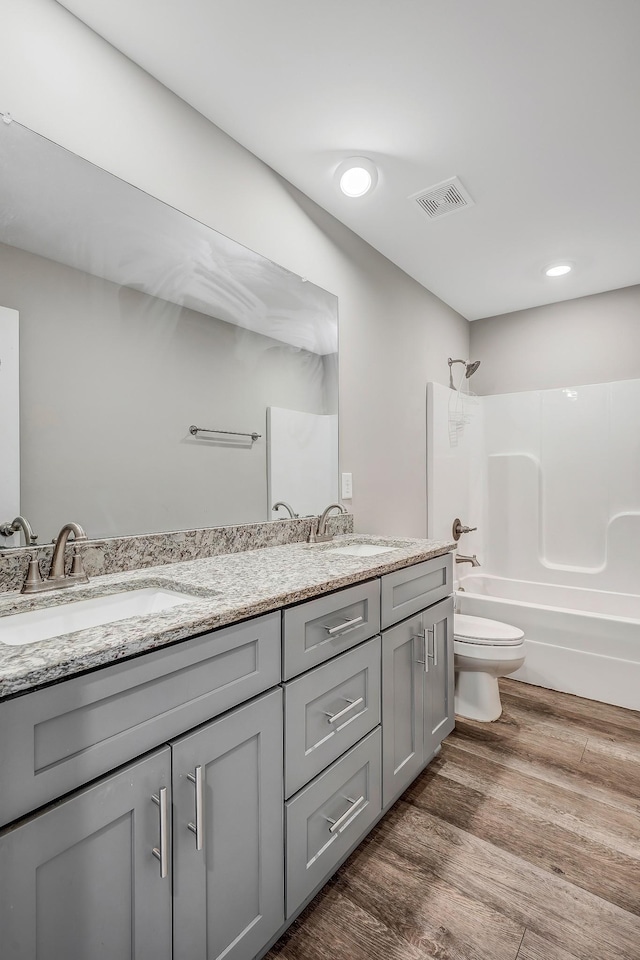 full bathroom with toilet, vanity, tub / shower combination, and hardwood / wood-style flooring