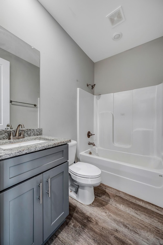 full bathroom featuring shower / bathing tub combination, vanity, hardwood / wood-style flooring, and toilet