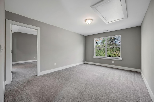 carpeted spare room with lofted ceiling