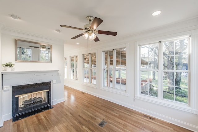 unfurnished living room featuring a multi sided fireplace, wood-type flooring, and a healthy amount of sunlight