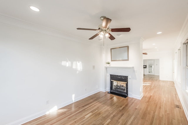 unfurnished living room with ceiling fan, light hardwood / wood-style floors, crown molding, and a high end fireplace