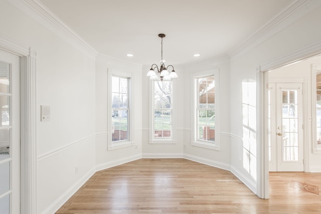 unfurnished dining area featuring light hardwood / wood-style floors, an inviting chandelier, and crown molding