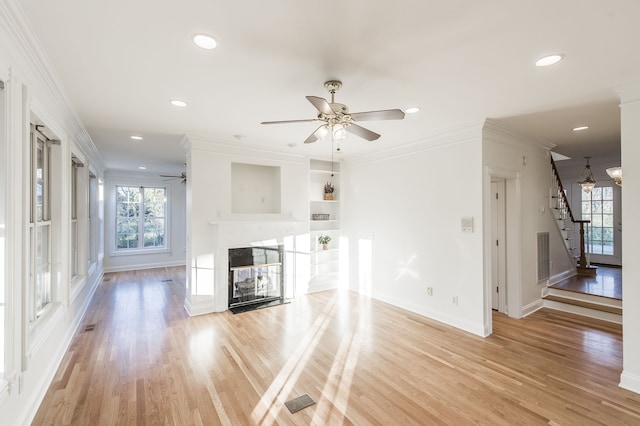 unfurnished living room with ceiling fan, light wood-type flooring, and ornamental molding