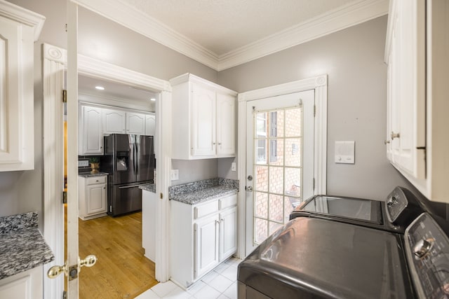 kitchen with stainless steel fridge, crown molding, light hardwood / wood-style flooring, white cabinets, and washing machine and dryer