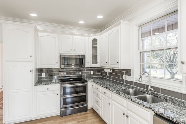 kitchen featuring white cabinets, dark stone countertops, sink, and stainless steel appliances