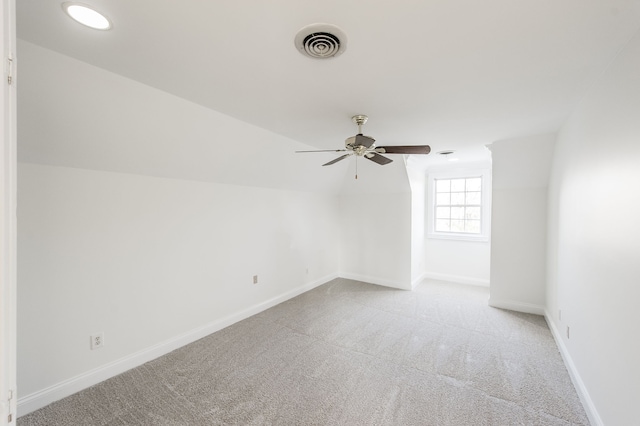 additional living space featuring light colored carpet, ceiling fan, and lofted ceiling