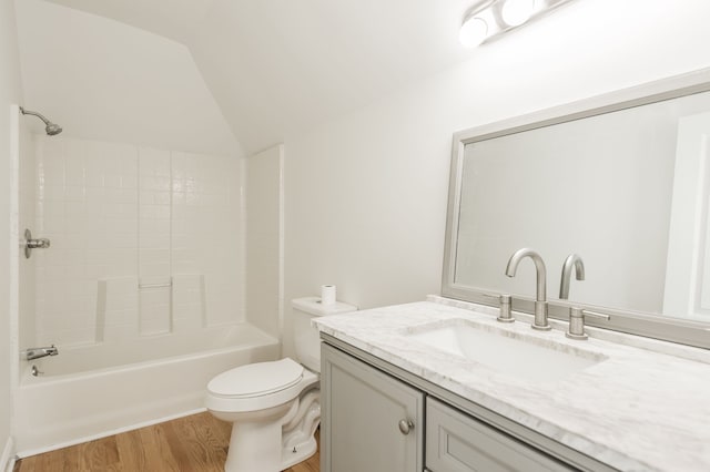 full bathroom with vanity, vaulted ceiling, hardwood / wood-style flooring, toilet, and shower / bath combination