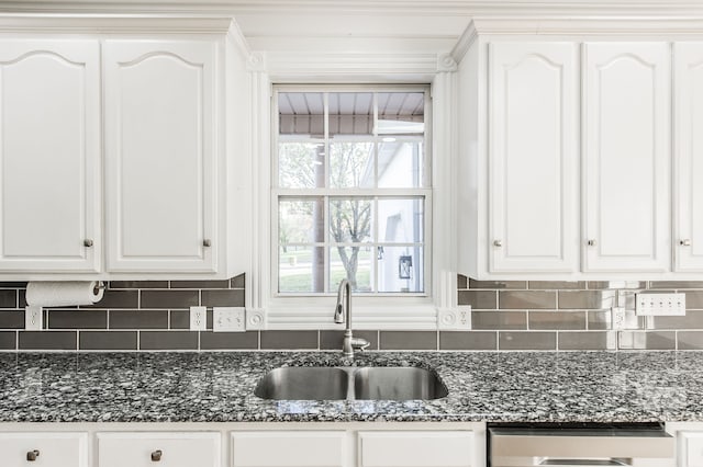 kitchen with white cabinetry, sink, dishwasher, backsplash, and dark stone countertops