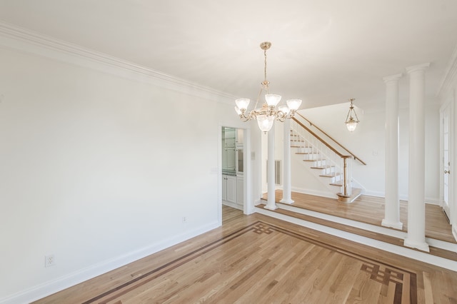 spare room with crown molding, hardwood / wood-style floors, and an inviting chandelier