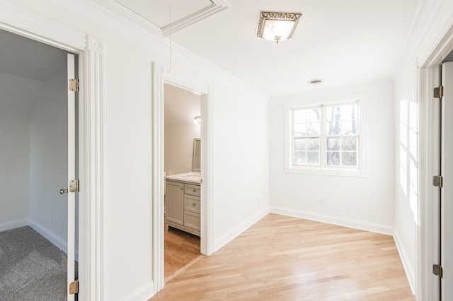 hallway featuring light wood-type flooring and crown molding