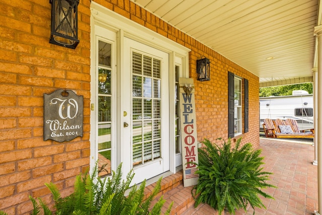 view of exterior entry with a porch