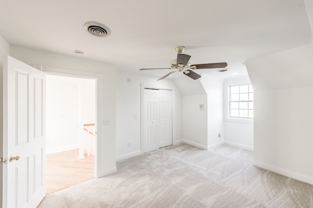 additional living space with ceiling fan, lofted ceiling, and light carpet