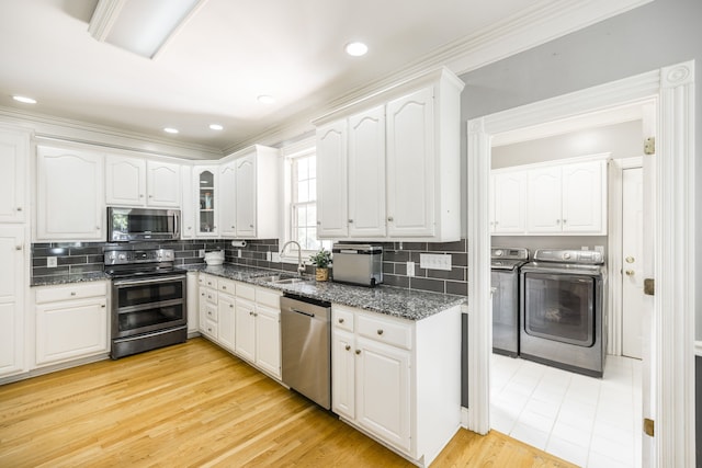 kitchen featuring white cabinetry, sink, independent washer and dryer, and stainless steel appliances