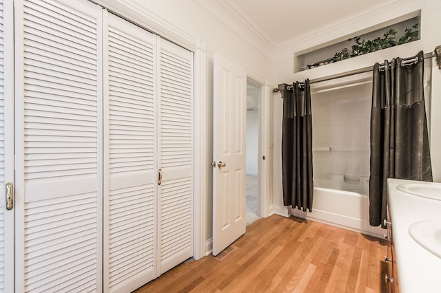 bathroom with hardwood / wood-style floors, vanity, shower / tub combo with curtain, and crown molding