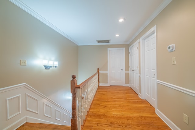 hallway featuring light wood-type flooring and ornamental molding