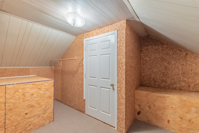 bonus room featuring wooden walls and vaulted ceiling