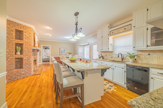 kitchen with sink, decorative backsplash, black dishwasher, light hardwood / wood-style floors, and white cabinetry