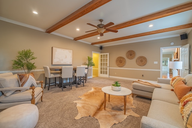 carpeted living room featuring ceiling fan, beam ceiling, and crown molding