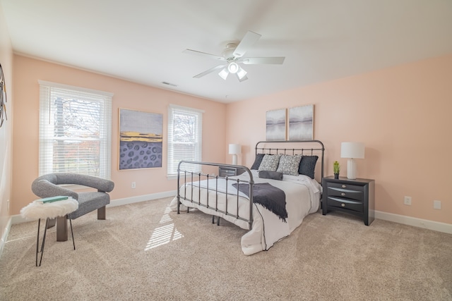 bedroom with light carpet, multiple windows, and ceiling fan